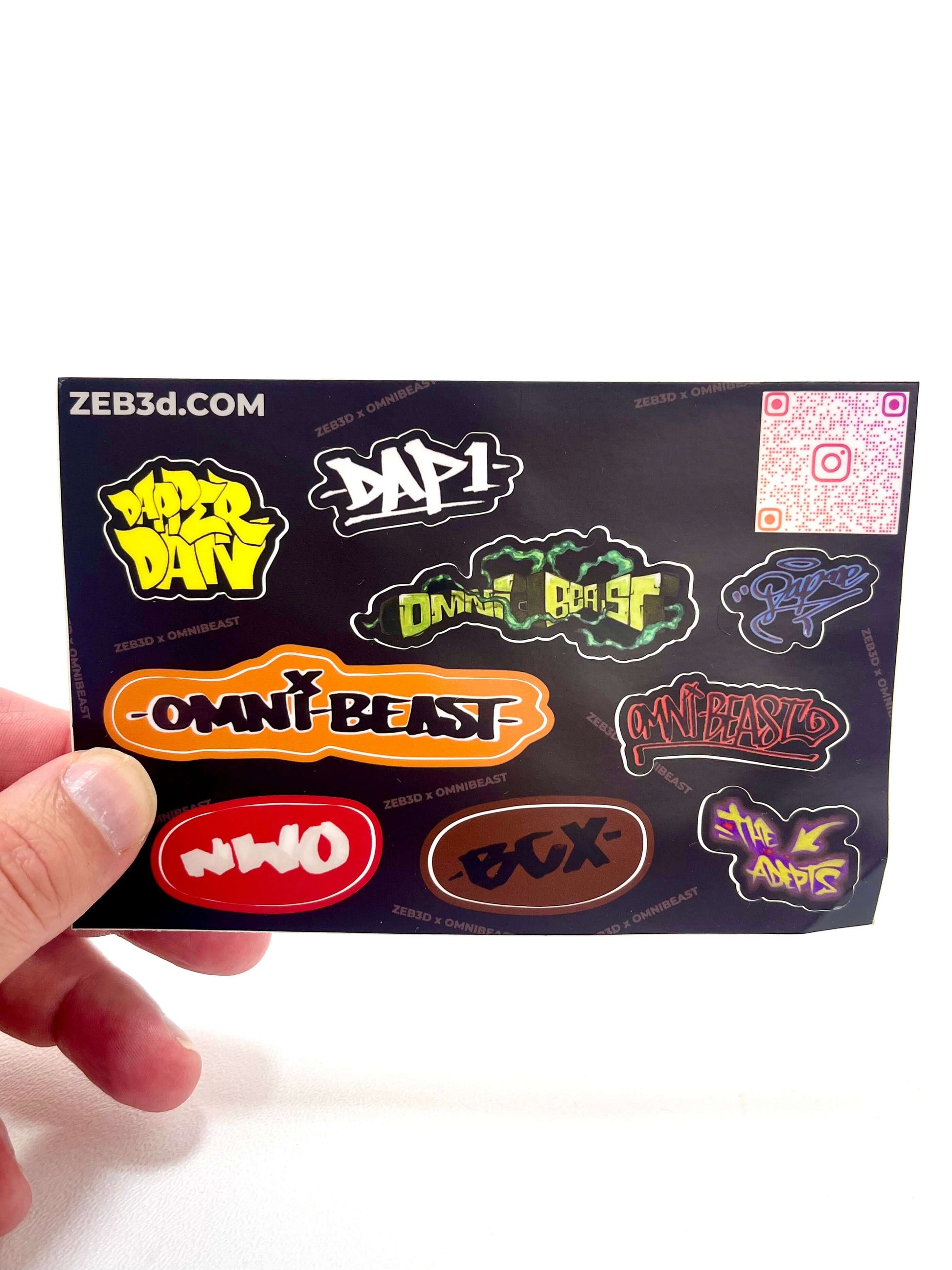 Hand holding a Zeb3D sticker sheet featuring colorful graffiti-style designs with text including Omni Beast and Duck Boost.