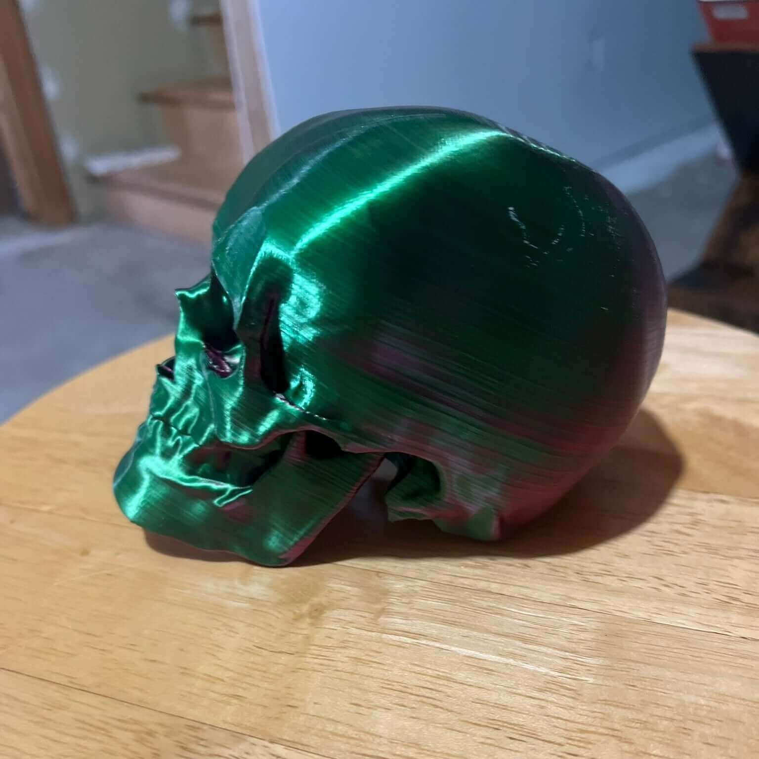 Dual color gradient 3D model replica of a human skull on a nightstand, showcasing realistic details and suitable for desk decor and human anatomy study.